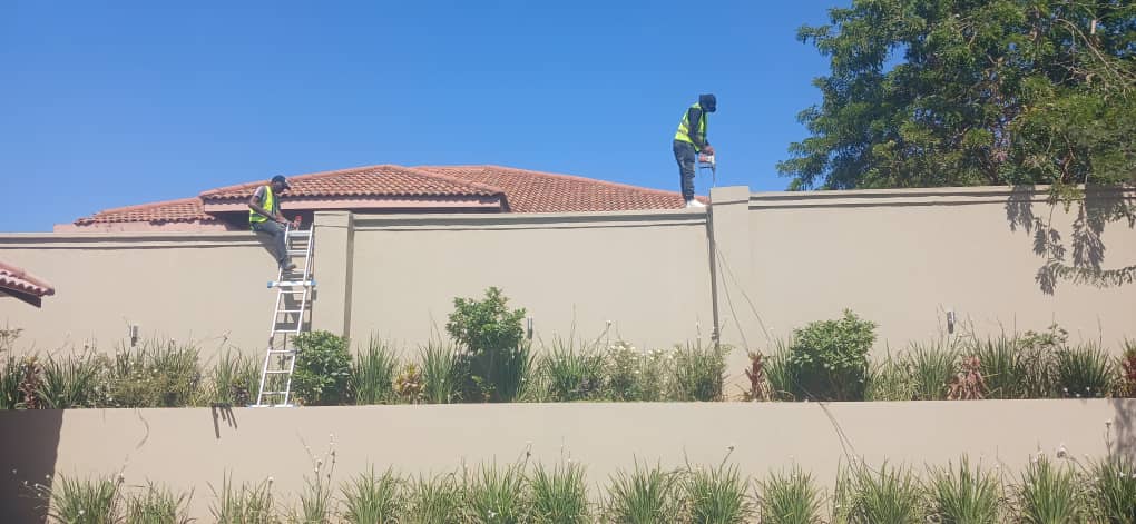 Electric fence installation along a boundary wall